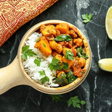 A bowl of food on a table, with Chickpea and Curry