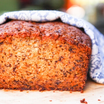 A loaf of banana bread wrapped in a blue and white cloth.