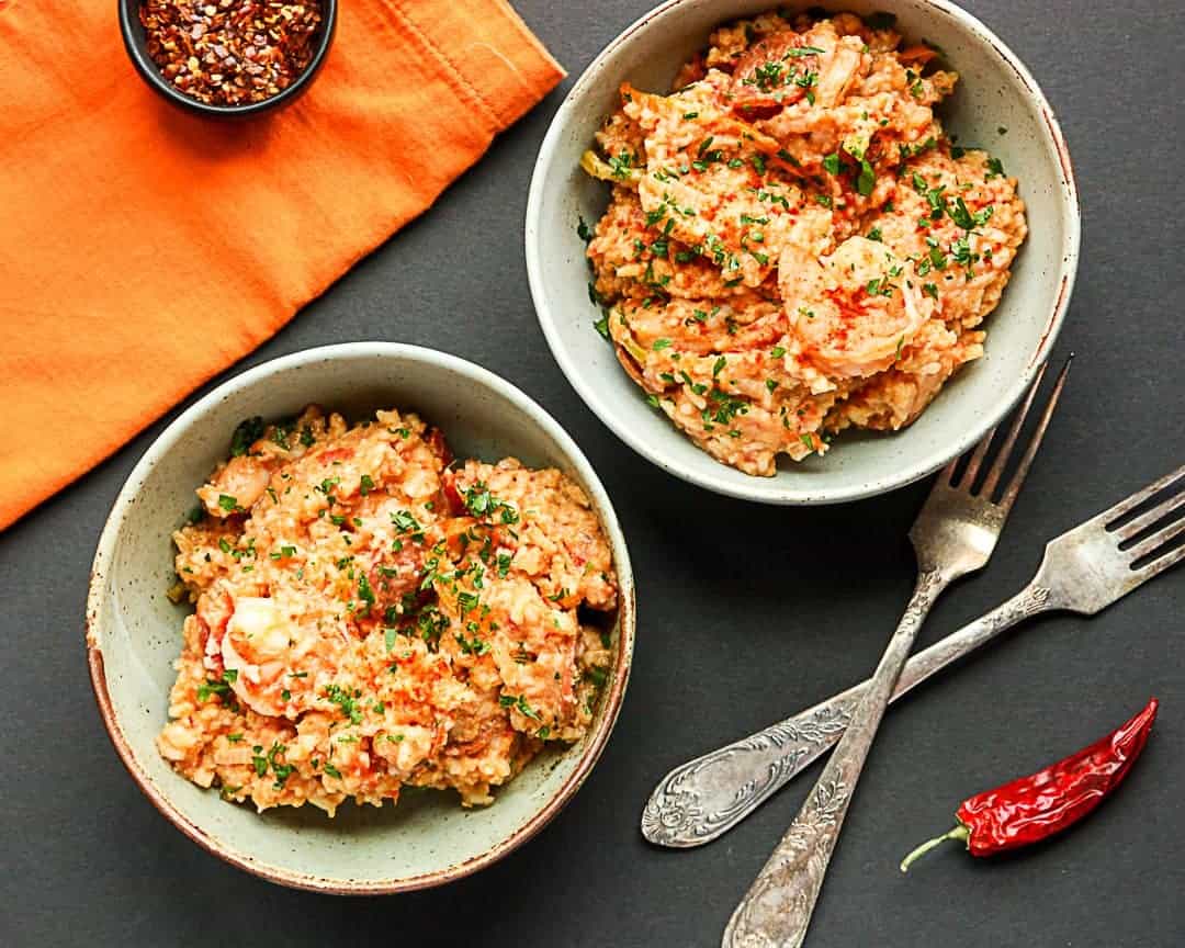 Two bowls of food and a dish of seasoning