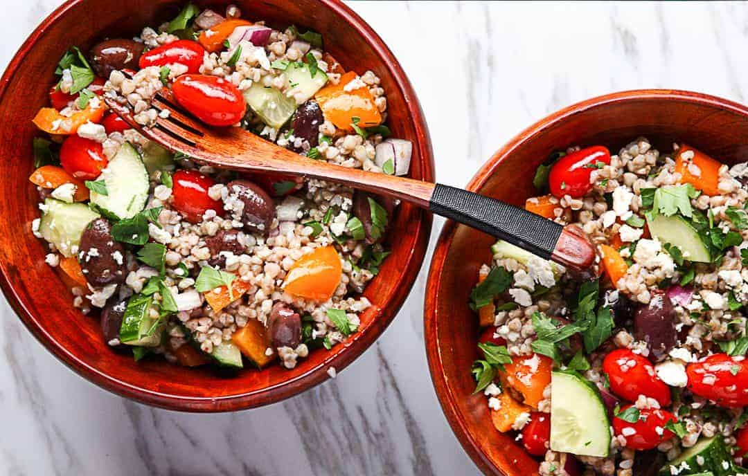 A bowl of gain and vegetables with a fork.