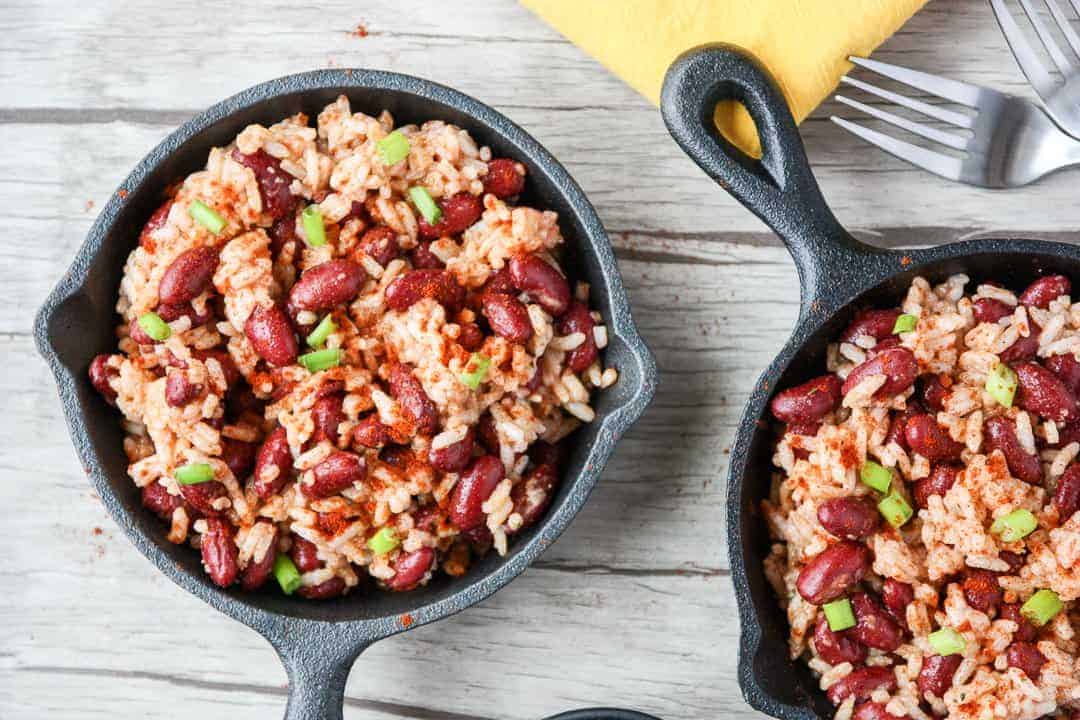 Red beans and rice in small black skillet on wooden table