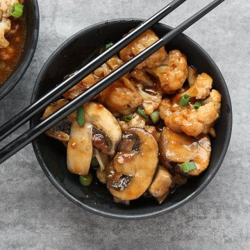 A bowl of food, with mushrooms and Cauliflower