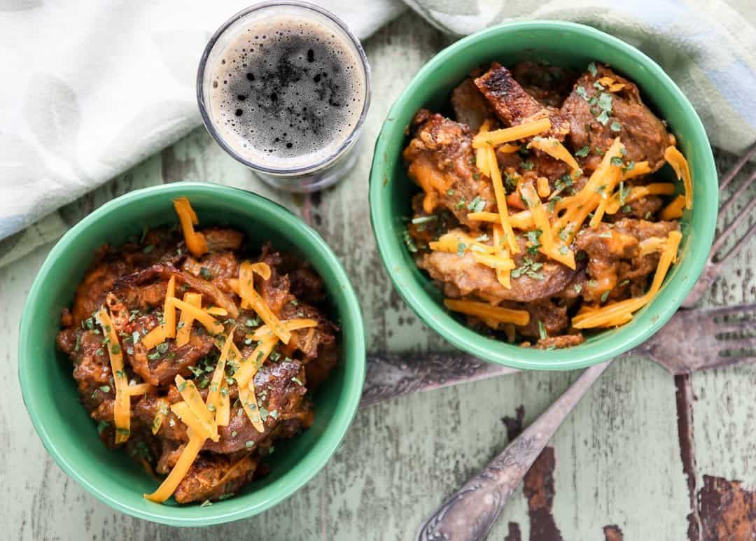 Two bowls of bread pudding, with a glass of beer