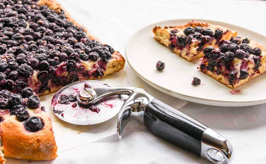 A piece of pie on a plate, with blueberries