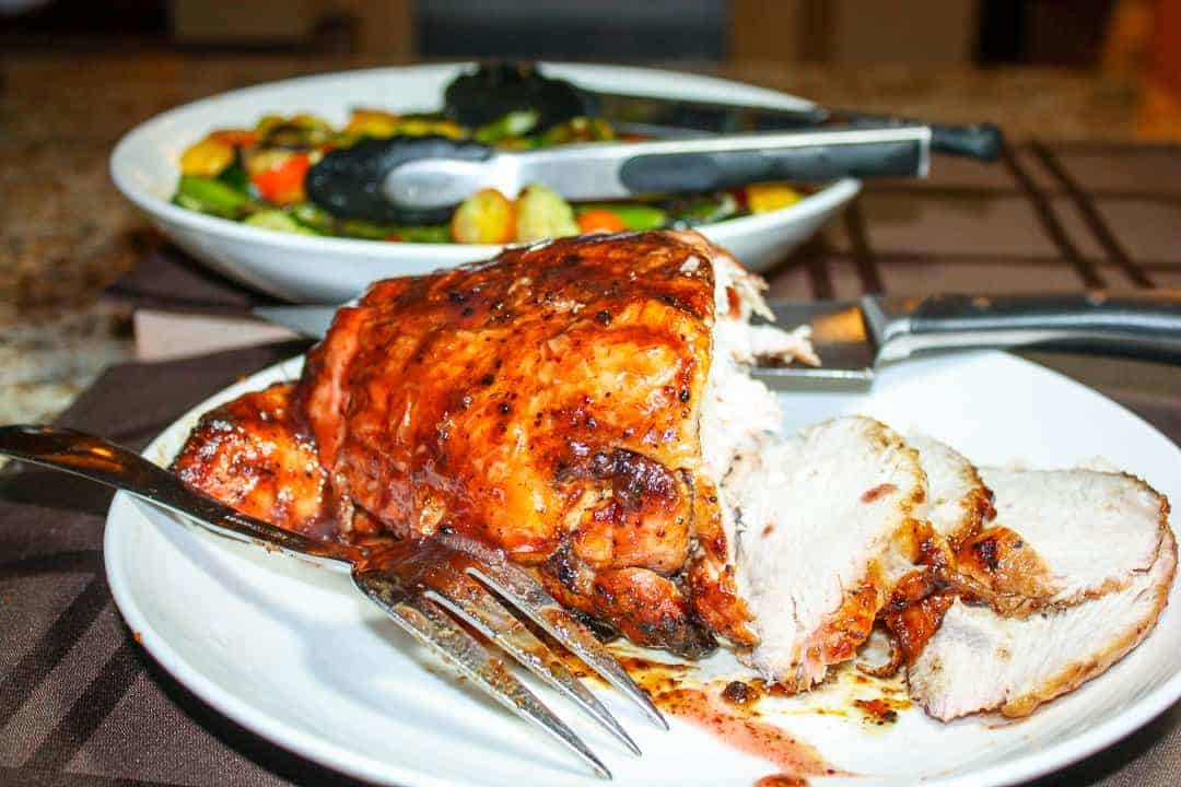 A cooked turkey breast is getting sliced