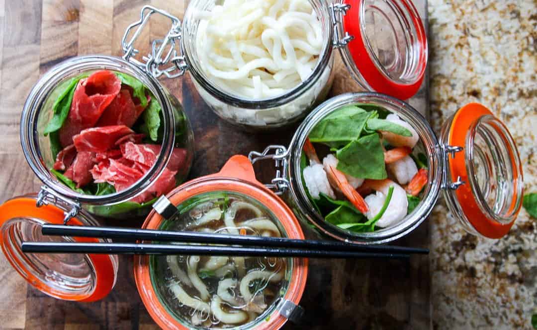 Noodles and beef in jars, with vegetables