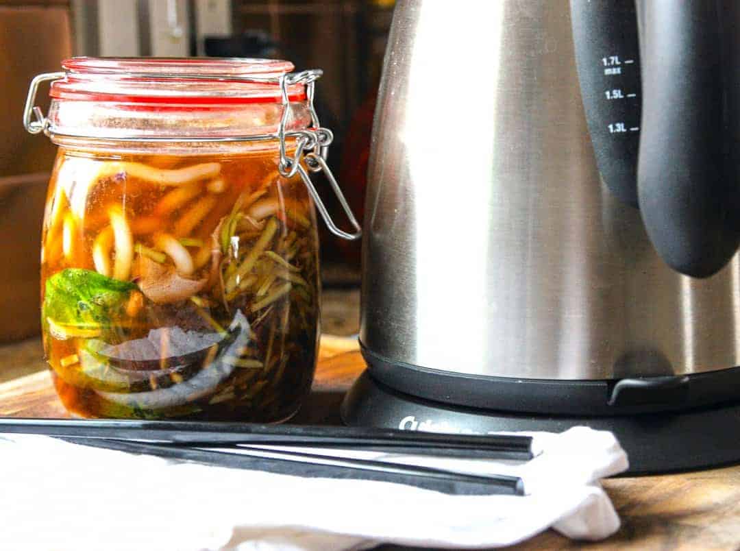 A jar of soup, with a kettle