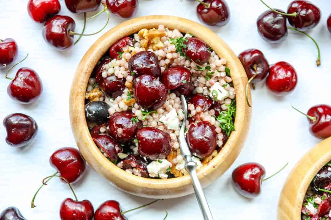 Salad with cherries in a wooden bowl