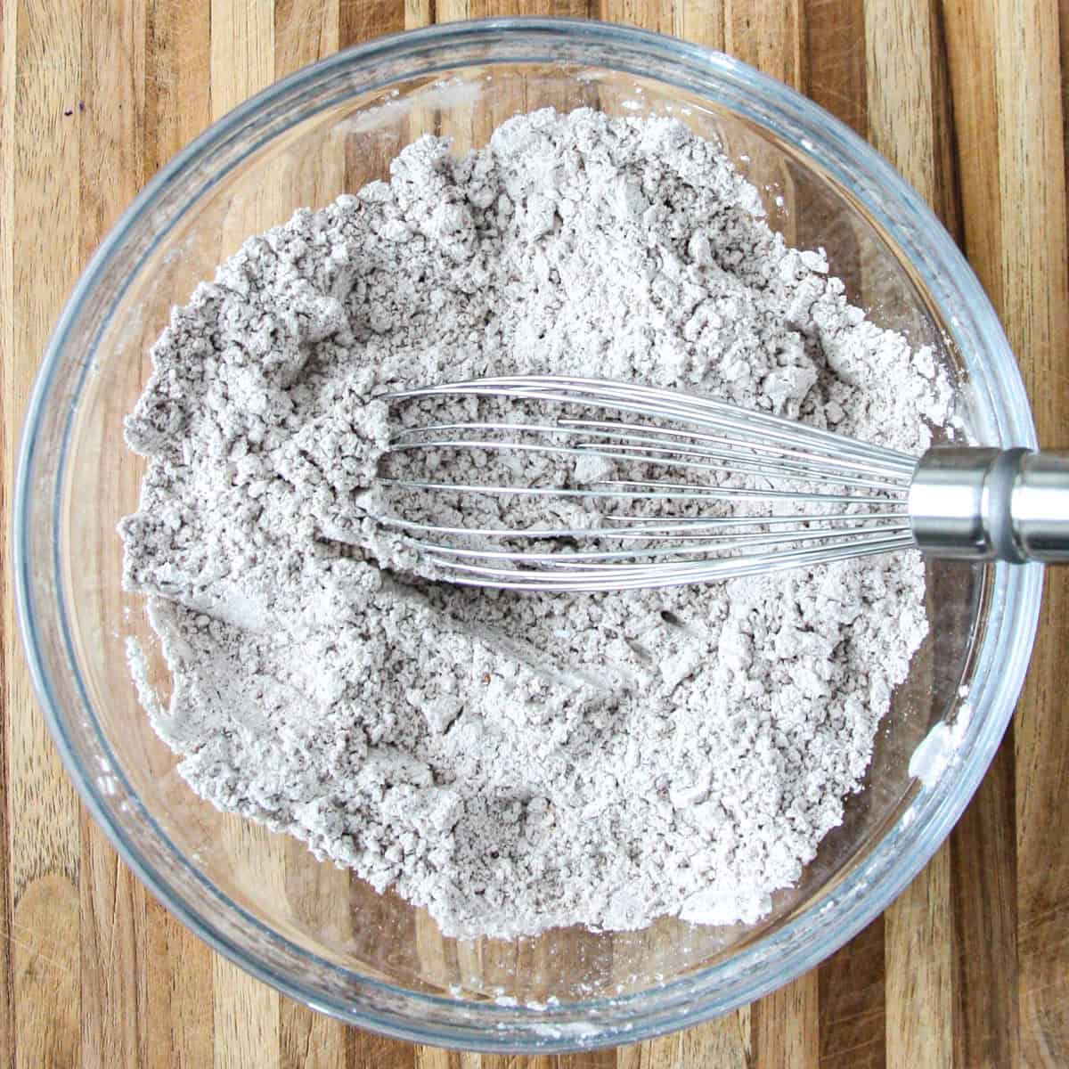 The flour, spices, baking soda, salt and baking powder in a glass bowl with a whisk.