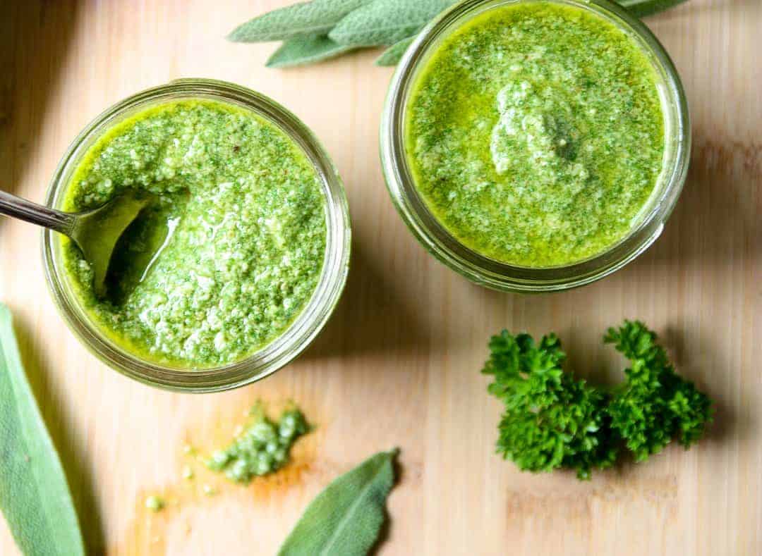 Two jars of pesto, with herbs