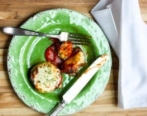 A plate of food sitting on top of a wooden table, with Stuffed mushrooms