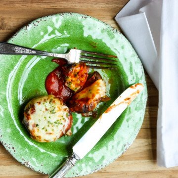 A plate of food sitting on top of a wooden table, with Stuffed mushrooms