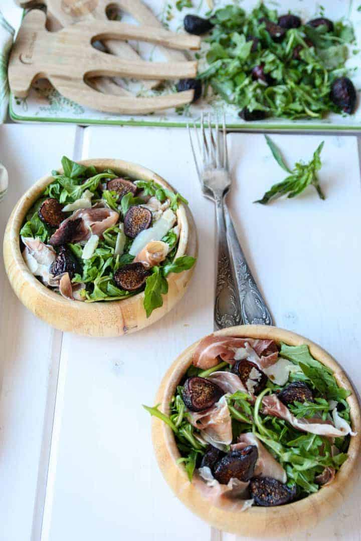 Two wooden bowls of salad with forks
