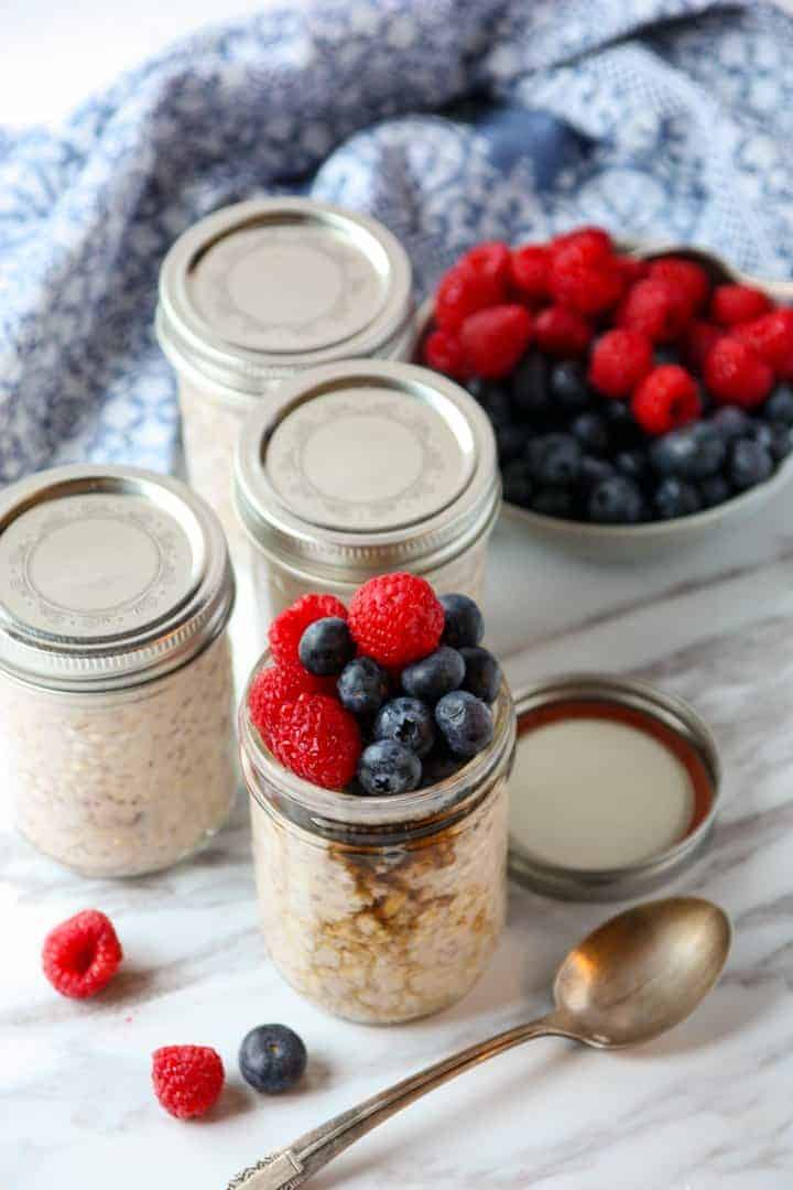 Jars of oatmeal and a bowl of berries