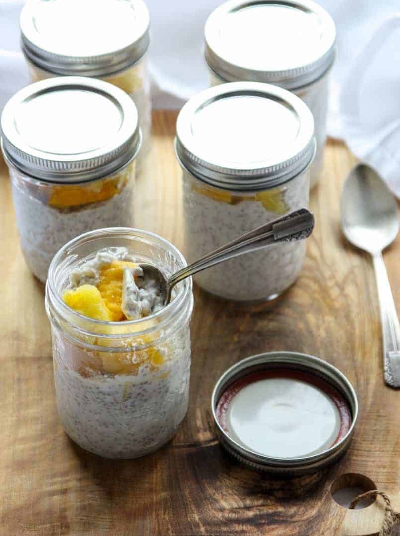 A glass jar of chia pudding with a spoon in it