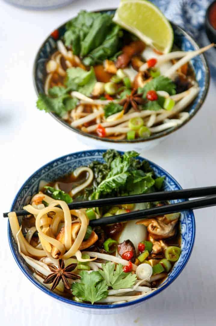 top shot of two bowls of Vietnamese soup with black chopsticks