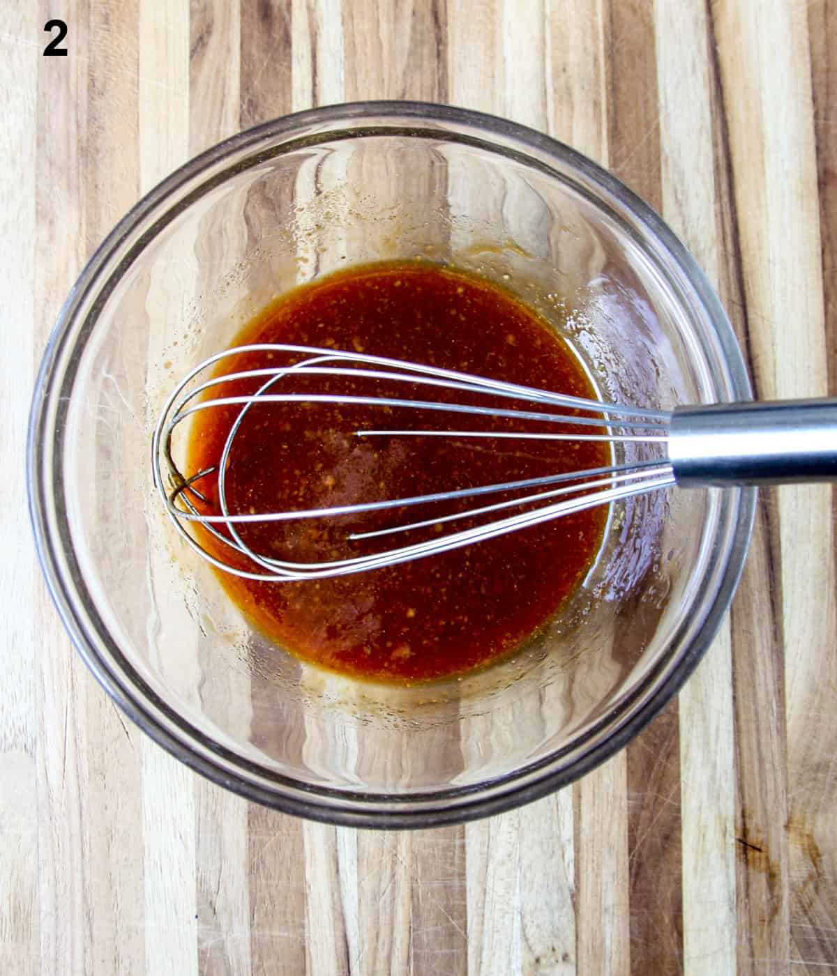 The miso glaze in a glass bowl with a whisk.