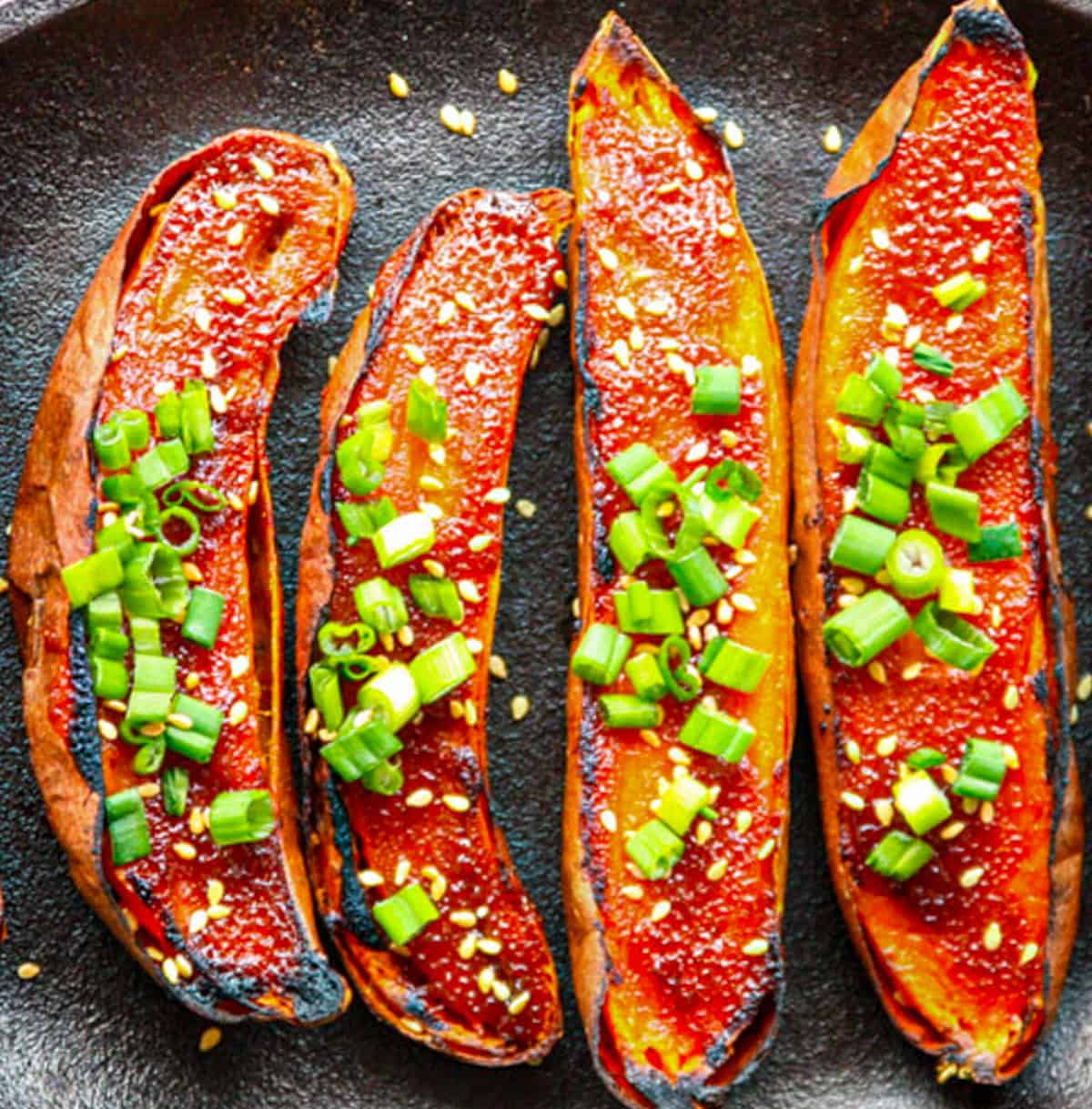 Glazed miso sweet potatoes garnished with sliced green onions.