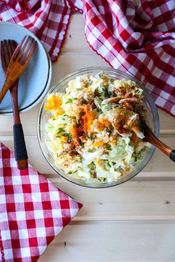 A bowl of food on a table, with Potato salad
