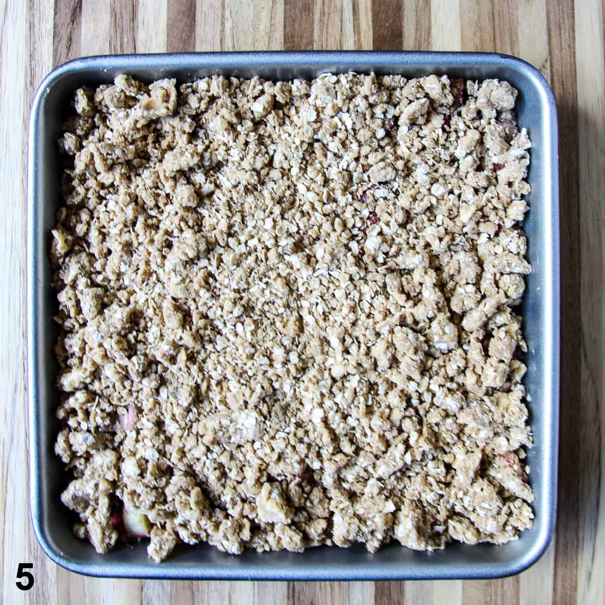 The topping is spread over the filling in the baking pan.