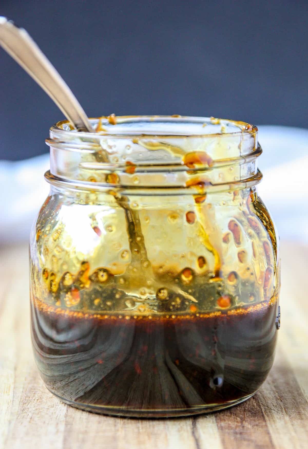 A glass jar half full of sauce.