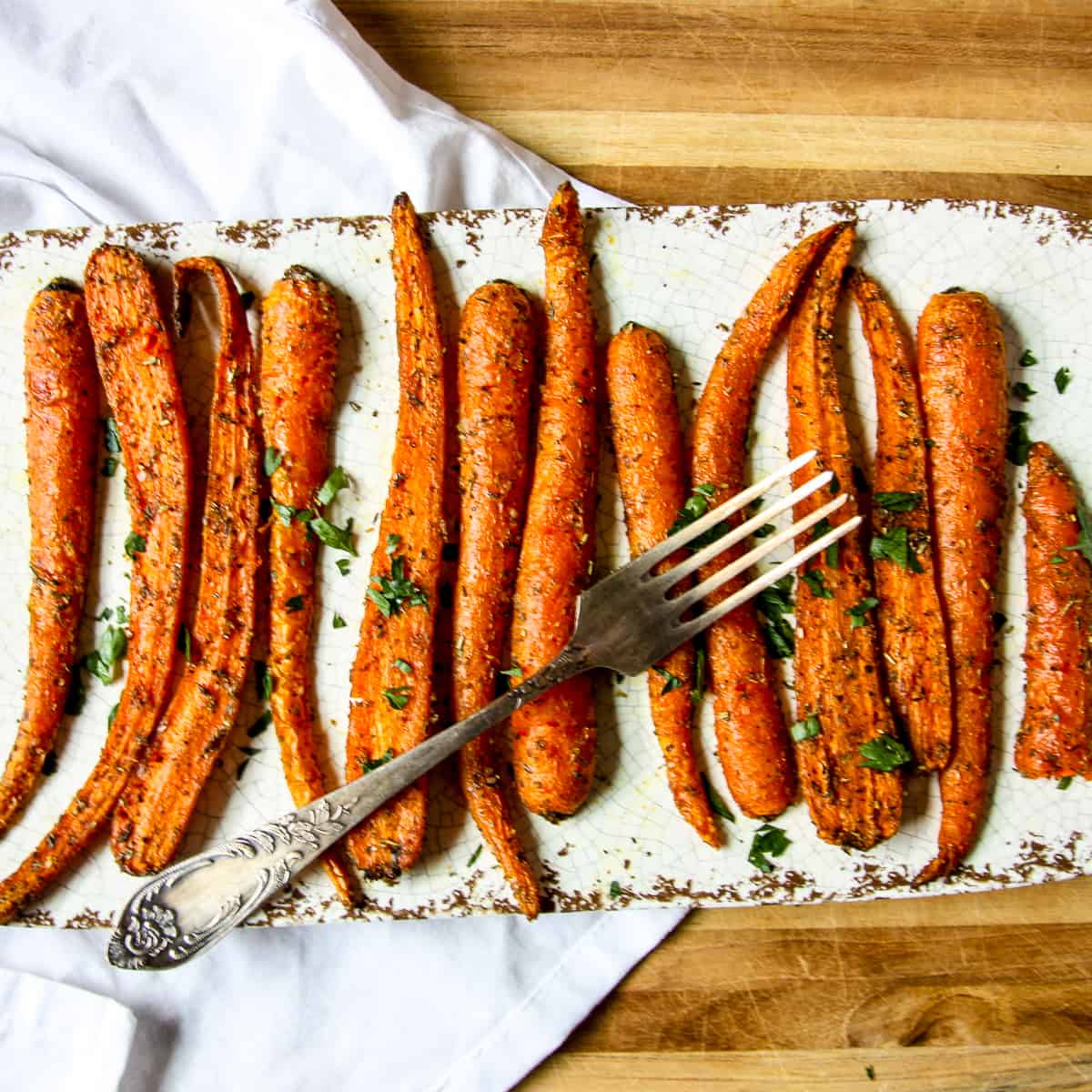 Air Fryer Carrots on a white plate with a fork.