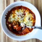 A pizza bowl on a wooden cutting board.