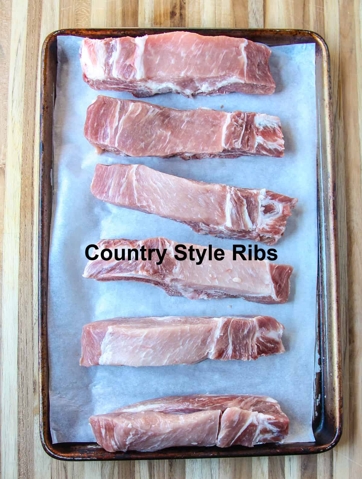 Uncooked ribs on a baking tray ready to be seasoned.