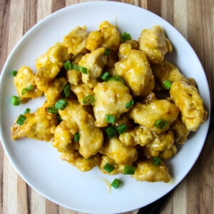 Air fried orange chicken garnished with green onions.