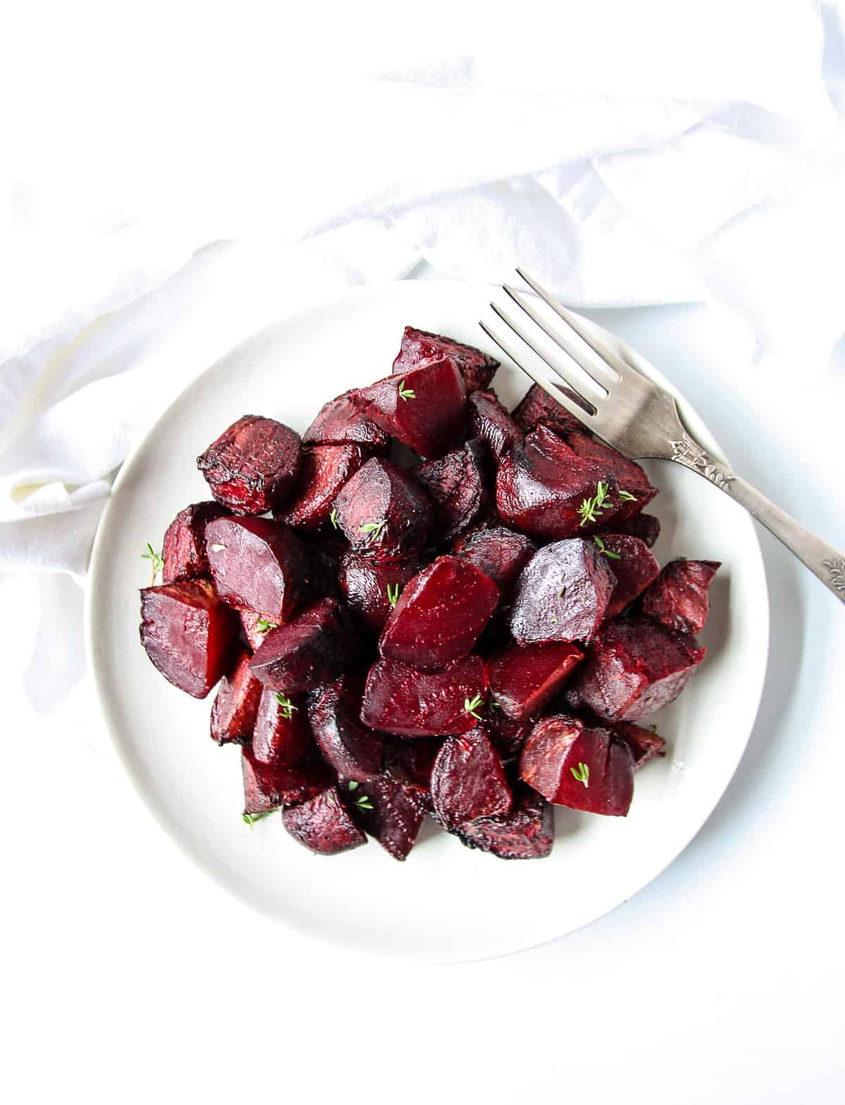 Air fried beets on a white plate with a silver fork.