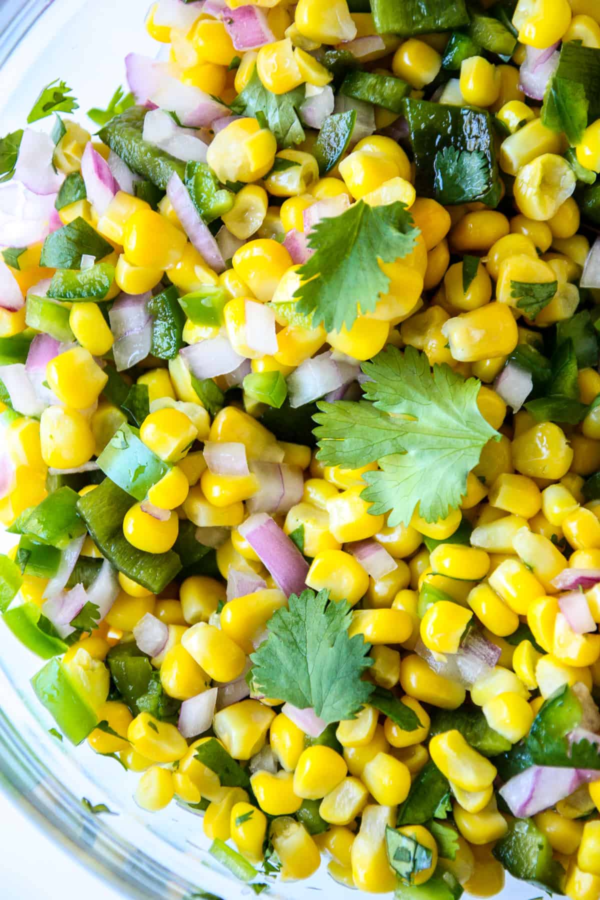 A close up of the corn salsa in a glass bowl.