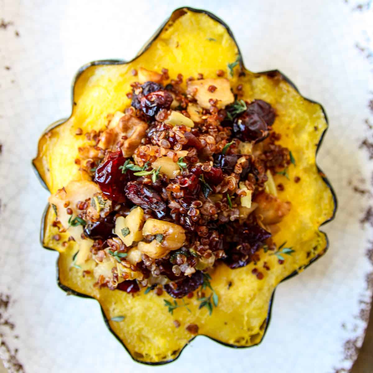Air fryer stuffed acorn squash on a speckled with plate.