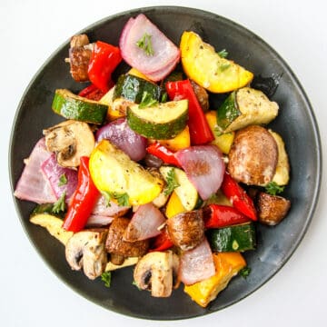 Air fryer roasted vegetables on a black plate.