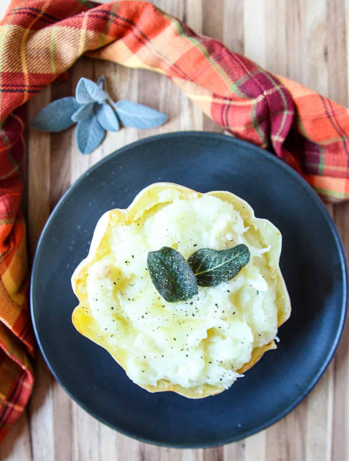 Mashed potato squash being served on a black plate.