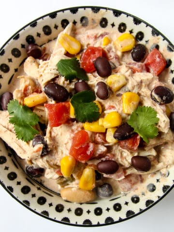 A black and white bowl filled with cream cheese chicken chili.