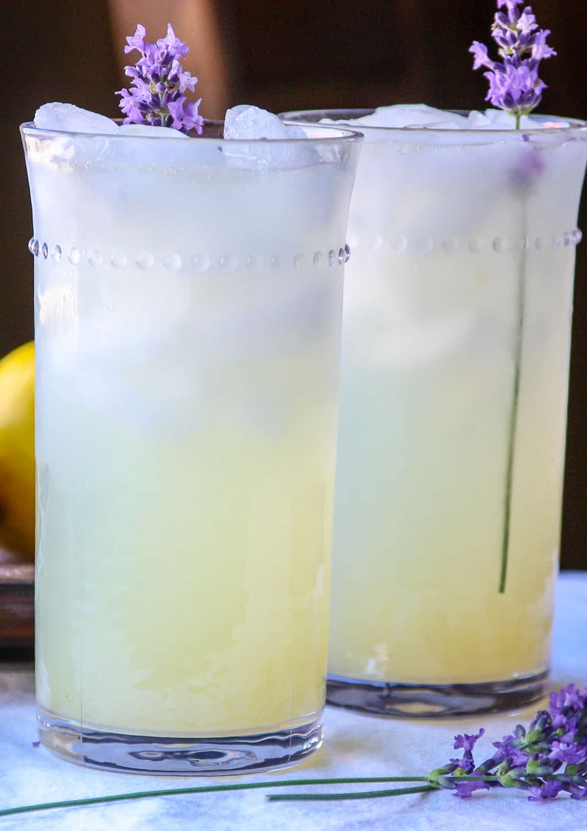 Two glasses of lavender lemonade, with sprigs of lavender.