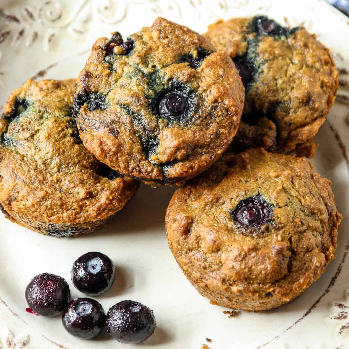 Almond flour blueberry muffins on a white plate.