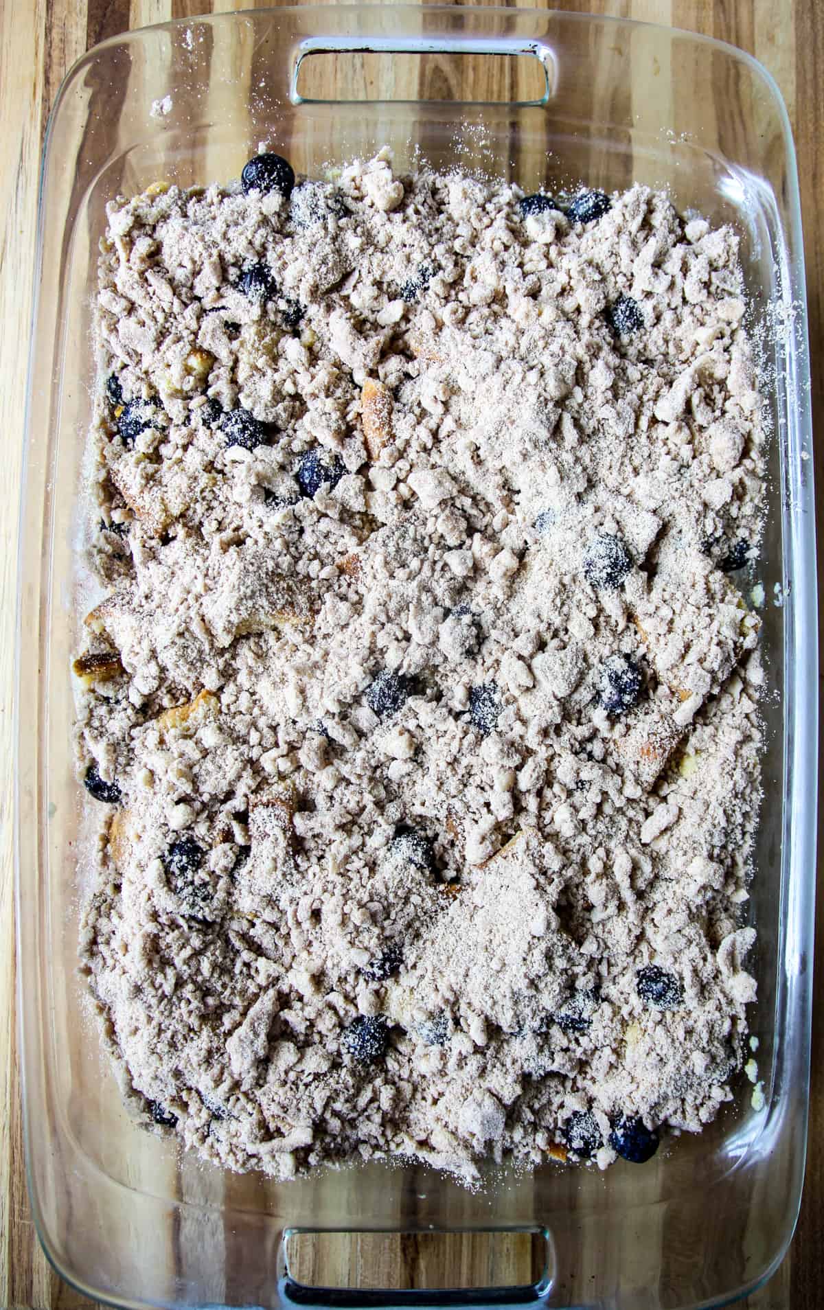 The unbaked casserole with streusel topping spread over the top.