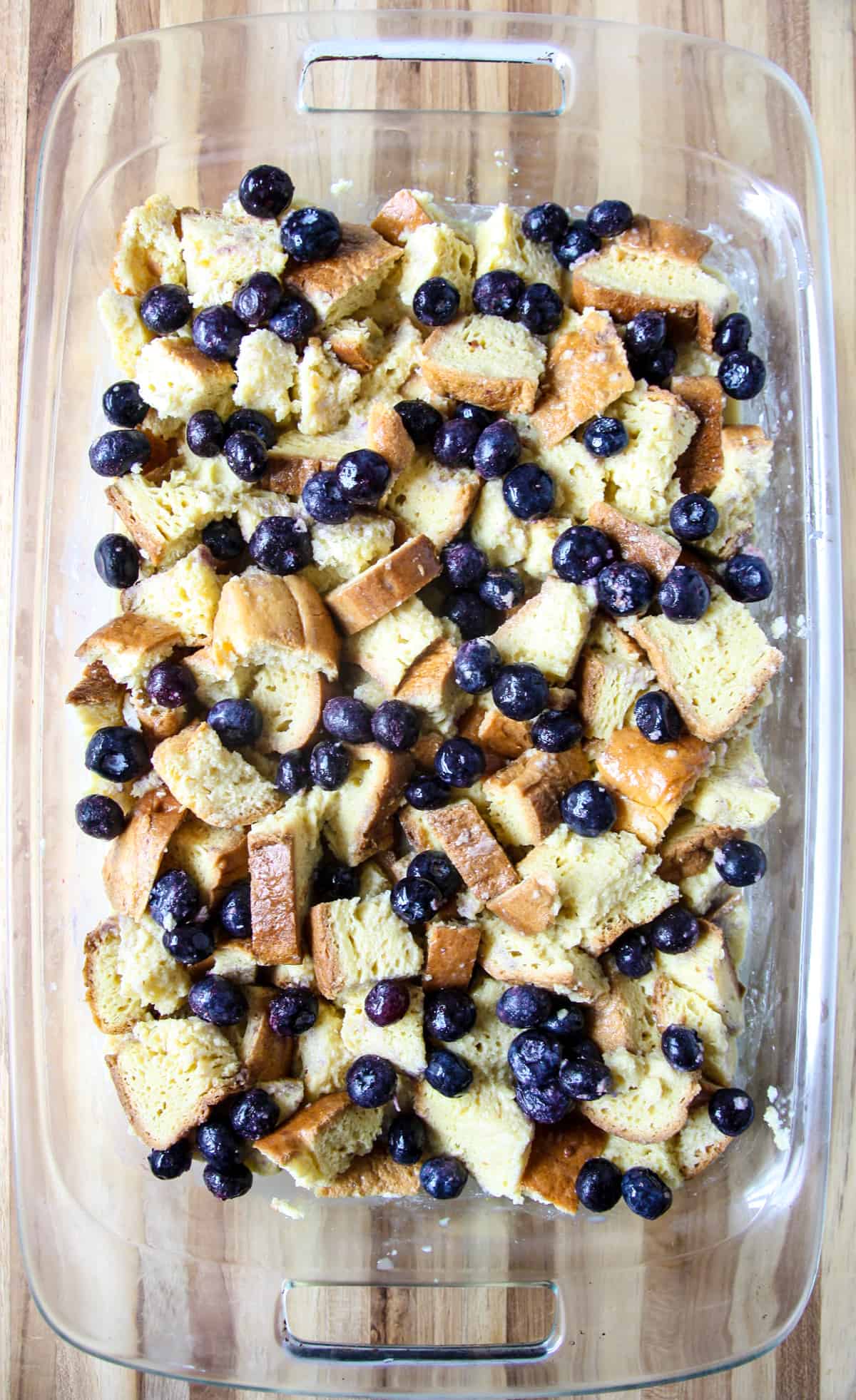 The unbaked French toast casserole topped with blueberries.