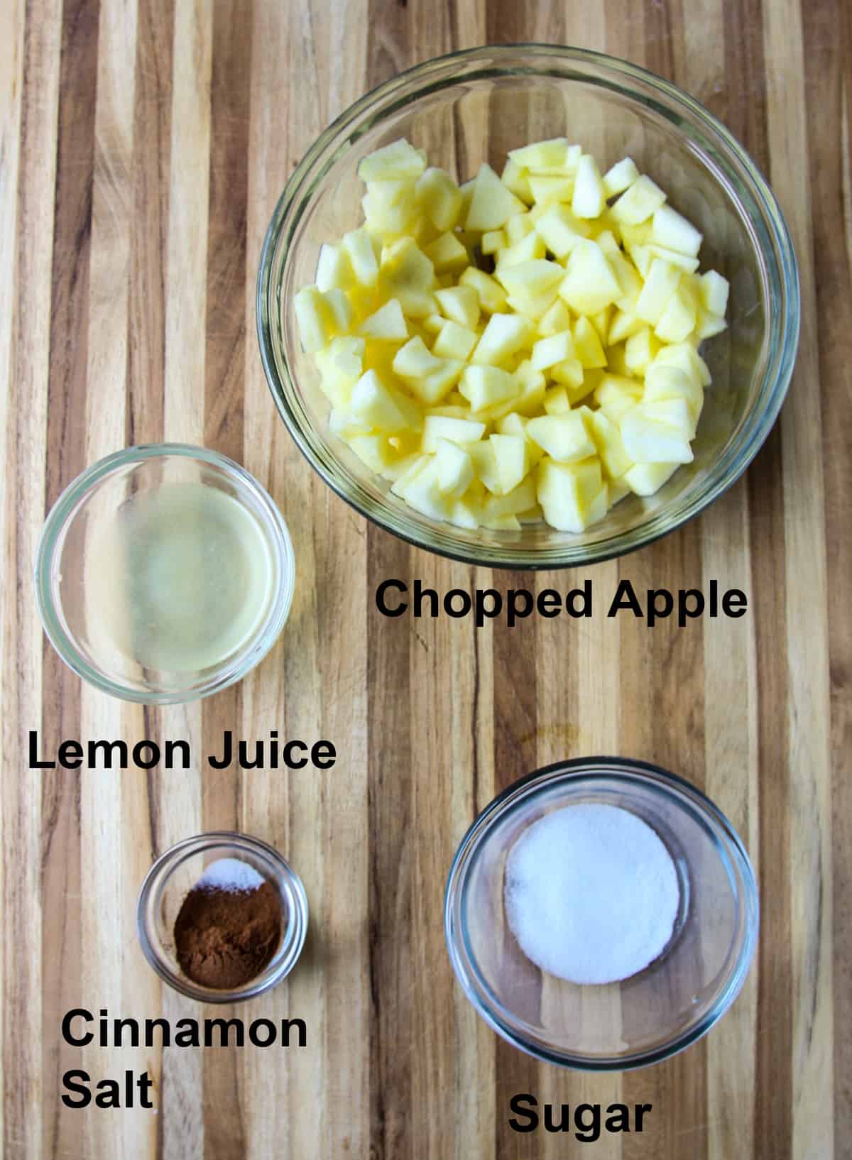 The ingredients for the apple crisp filling in glass bowls.