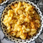 Old fashioned baked macaroni and cheese in a black and white bowl.