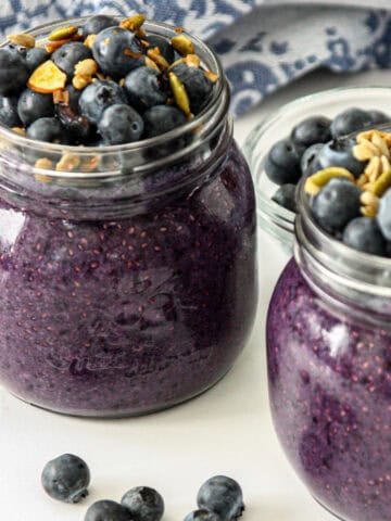 Blueberry chia pudding in two glass jars.
