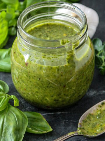 Basil chimichurri sauce in a glass jar.